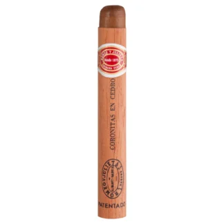 A Romeo y Julieta Coronitas En Cedro cigar wrapped in a cedar sleeve, featuring its iconic red and gold band. The cigar rests elegantly on a rustic wooden surface, highlighting its premium craftsmanship and Cuban heritage. Perfect for a medium-bodied smoking experience with hints of cedar, spice, and sweetness.