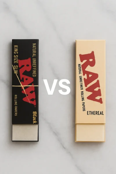 Vertical display of RAW Black and RAW Ethereal rolling paper packs on a marble surface with VS text in the center, highlighting brand comparison.